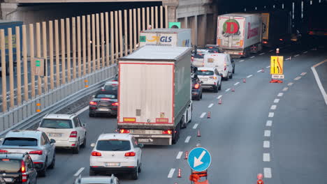 Heavy-traffic-scene,-trucks-and-cars-driving-slowly-due-to-road-repair-work