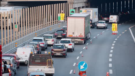 Toma-De-Teleobjetivo-De-La-Carretera-En-Mantenimiento,-Muchos-Automóviles-Y-Camiones-Conduciendo-Lentamente