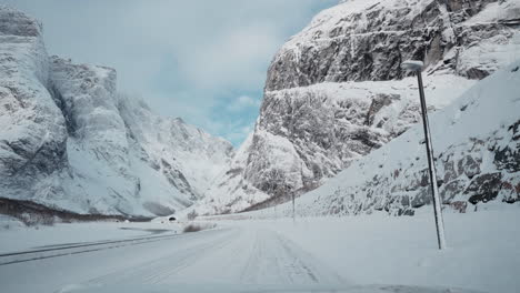 A-Breathtaking-POV-Drive-through-Norway's-Majestic-Snow-Covered-Landscape,-Passing-Trollveggen,-the-Enchanting-and-Exhilarating-Mountainside-Wonder