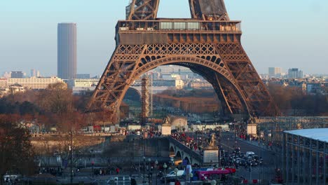 Tráfico-Urbano-De-Personas-Y-Vehículos-En-Las-Calles-Bajo-La-Torre-Eiffel-En-París,-Tiro-En-Tiempo-Real