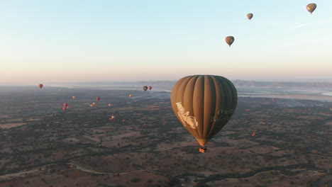 Hot-air-balloons-flying-over-the-plains-of-Bagan,-Myanmar-during-sunrise