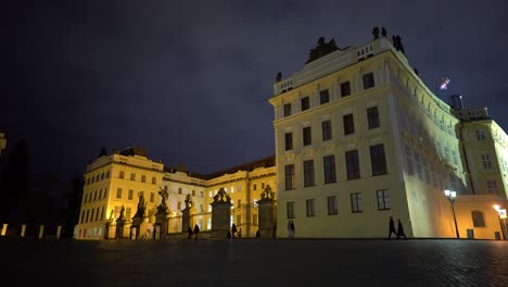 Caminando-Frente-Al-Complejo-Del-Castillo-De-Praga-Con-Gente-De-Noche