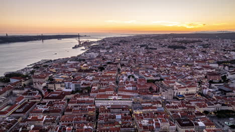 Timelapse-aerial-timelapse-of-Lisbon-city-sunset,-portugal,-orbit-movement-with-timelapse-over-alfama,-baixa-y-chiado-and-bairro-alto