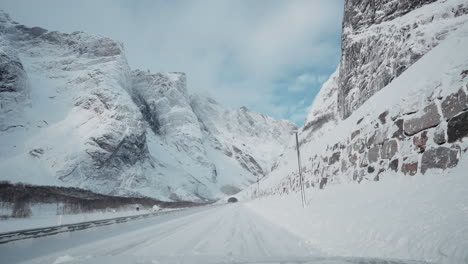 A-Breathtaking-POV-Drive-through-Norway's-Majestic-Snow-Covered-Landscape,-Passing-Trollveggen,-the-Enchanting-and-Exhilarating-Mountainside-Wonder