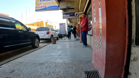 Vista-De-La-Actividad-En-Una-Calle-De-La-Ciudad-Fronteriza-Mexicana-Cerca-De-Un-Dentista-Y-Una-Farmacia