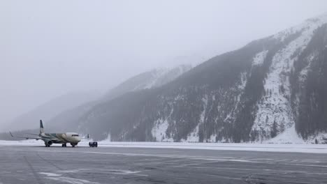 Plane-on-a-snow-covered-runway-at-Samedan-Airport-in-Engadin,-Airport,-Switzerland