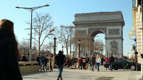 pedestrian-traffic-on-the-paris-sidewalk-in-front-of-a-famous-monument,-real-time-shot