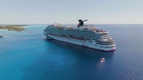 Aerial-view-around-the-Carnival-dream-cruise-liner-at-Little-San-Salvador-Island,-in-sunny-Bahamas