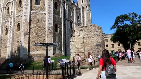 Tilting-shot-reveals-a-female-tourist-heading-to-explore-the-Tower-of-London,-UK