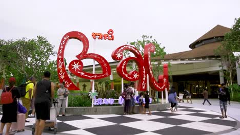 Kultiges-„Welcome-To-Bali“-Schild-Am-Indonesischen-Flughafen.-An-Bewölkten-Tagen-Versammeln-Sich-Menschen