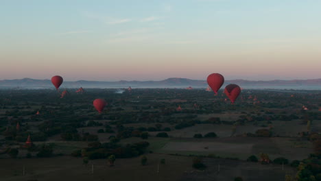 Globos-Aerostáticos-Sobre-Las-Llanuras-De-Bagan,-Myanmar,-Hermosa-Toma-Aérea-Cinematográfica