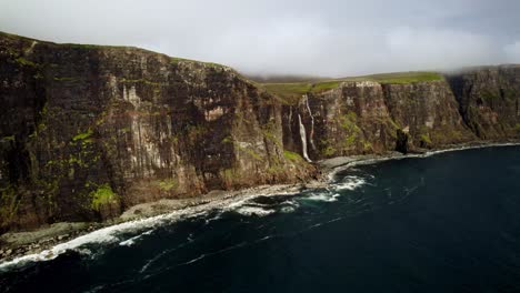 Breathtaking-Waterfalls-Pour-Into-Ocean-From-Mossy-Green-Cliffs,-Skye-Scotland