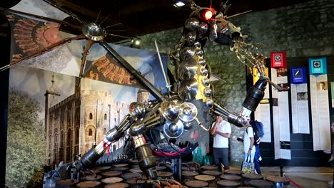 Slow-motion-shot-of-tourists-admiring-a-dragon-built-with-metal-pieces-in-the-Tower-of-London