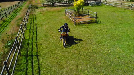 Hombre-Mayor-En-Motocicleta-En-Campo-Verde-En-Una-Granja-Canadiense