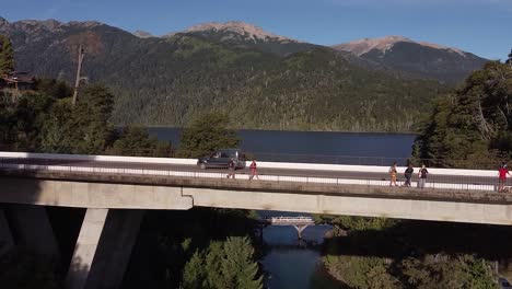 Brücke-über-Den-Fluss-Correntoso-Mit-Dem-See-Nahuel-Huapi-Und-Den-Bergen-Im-Hintergrund