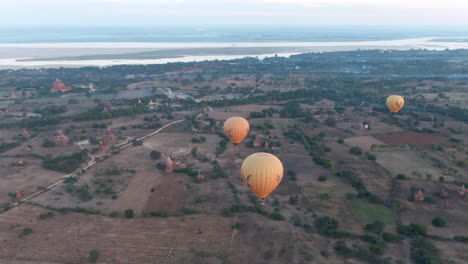 Grupo-De-Globos-Aerostáticos-Volando-Bajo-Sobre-Las-Llanuras-Y-Templos-De-Bagan-Antes-Del-Amanecer