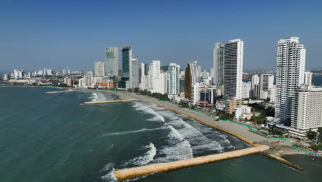 Drone-shot-rising-in-front-of-Bocagrande-beach-and-skyline,-sunny-day-in-Cartagena,-Colombia