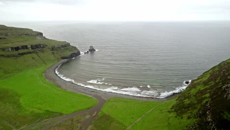 Waves-Roll-Onto-Green-Coastline,-Talisker-Bay-Beach-Scotland,-Drone-Aerial-Shot
