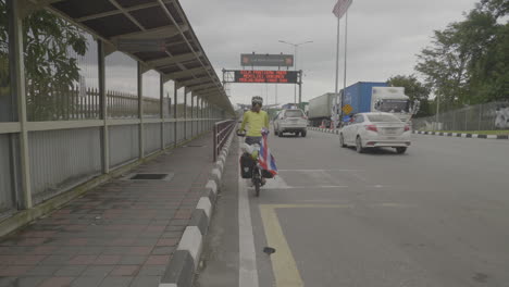 Woman-cyclist-mounts-bike-in-preparation-of-crossing-Thailand-Malaysia-border