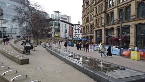 Exchange-Square,-Manchester,-showing-old-and-new-building-facades-and-people-shopping,-Manchester,-England,-UK