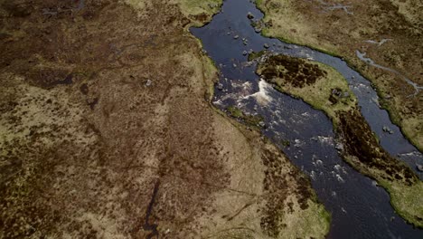 El-Agua-Del-Río-Oscuro-Rica-En-Minerales-Fluye-A-Través-De-Los-Humedales,-Isla-De-Skye,-Escocia
