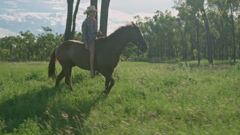 Girl-riding-a-horse-on-a-farm-at-dusk