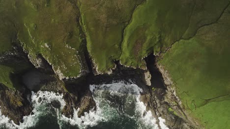 Sea-Mist-Clears-As-Waves-Crash-Onto-Sheer-Coastal-Green-Cliffs,-Skye-Scotland