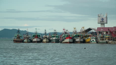 Fila-De-Barcos-De-Pescadores-Atracados-Por-El-Puerto-Sabah-Fish-Marketing-Sdn-Bhd-En-La-Bahía-De-Kota-Kinabalu,-Malasia