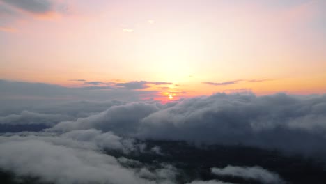 Vista-Aérea-Del-Sol-Saliendo-Por-Encima-De-Las-Nubes