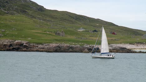 A-shot-of-a-sailing-vessel-with-a-Gannet-sea-bird-diving-for-fish-off-the-coast-of-Scarp,-near-Hushinish-on-the-Isle-of-Harris