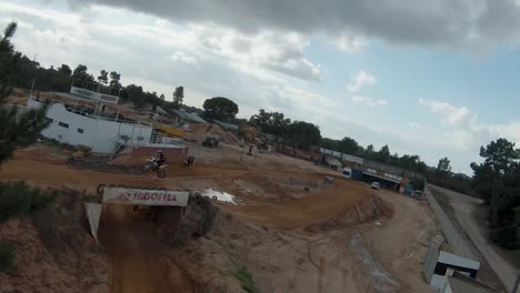 Motocross-rider-jumping-over-a-dirt-ramp-on-a-circuit