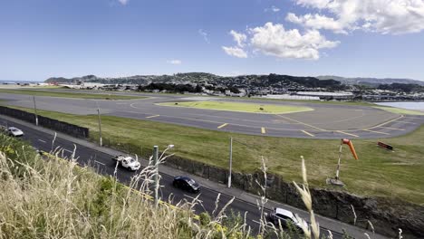 Autos-Fahren-Tagsüber-Neben-Der-Landebahn-Des-Internationalen-Flughafens-Wellington-In-Rongotai,-Neuseeland