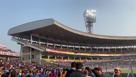 Schwenk-Des-überfüllten-Cricketstadions-Eden-Gardens-Während-Eines-Spiels-Zwischen-Indien-Und-Sri-Lanka-In-Kalkutta,-Westbengalen,-Indien,-Mit-Flutlichtern-Im-Hintergrund-Am-Abend