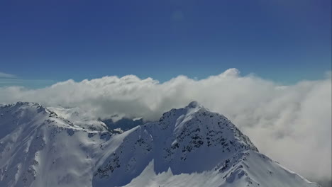Verschneiter-Berg,-Der-An-Einem-Sonnigen-Tag-In-Wolken-Gehüllt-Ist