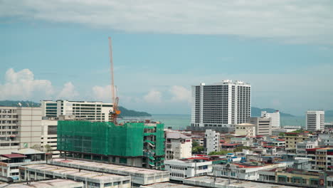 Kota-Kinabalu-Skyline-Zooming-to-Apartment-Building-Construction-Site-with-Crane-on-Top-on-Sunny-Day