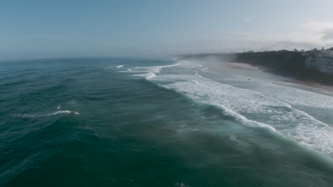 Aerial-dolly-over-salty-ocean-spray-coming-off-top-of-crashing-waves