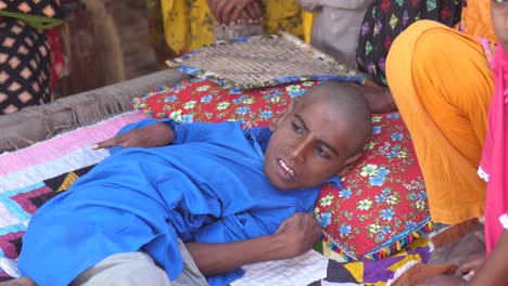 Niño-Paquistaní-Discapacitado-Acostado-En-La-Cama-Afuera-En-Sindh