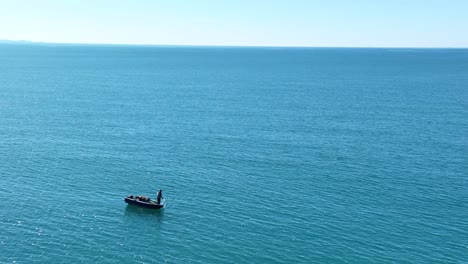 Pescador-Solitario-Tira-De-La-Línea-Desde-Las-Profundidades-Del-Océano-En-Un-Día-Soleado