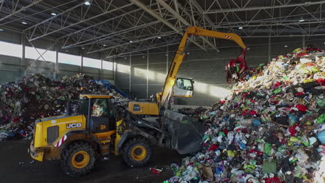 Bulldozer-Y-Grúa-De-Agarre-Trabajando-Dentro-De-Una-Instalación-Gigante-Que-Clasifica-Los-Desechos-De-Basura