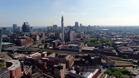 Vista-Aérea-Del-Paisaje-Urbano-De-Birmingham-Con-El-Tren-Acercándose-A-La-Estación-De-La-Colina-De-Nieve-Contra-El-Telón-De-Fondo-De-La-Emblemática-Torre-Bt