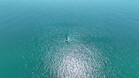 Birdseye-view-of-lone-boat-in-middle-of-ocean-on-sunny-day