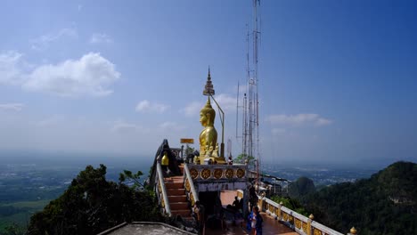 Gran-Buda-En-La-Cima-De-La-Montaña-A-La-Luz-Del-Día-Brillante-Y-Fondo-Azul