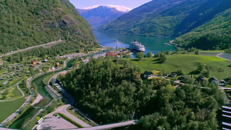 Stunning-green-mountains-surround-waterway-with-cruise-liner-docked-at-port