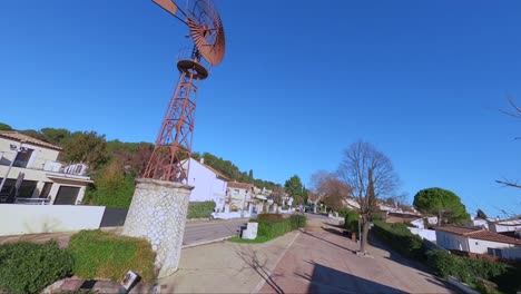 Spannender-FPV-Drohnenflug-Um-Eine-Riesige,-Alte-Windmühle-Im-Herzen-Eines-Dorfes
