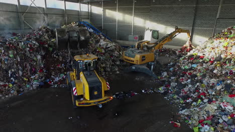 Bulldozer-Schaufelt-Einen-Haufen-Plastikmüll-In-Einer-Recyclingfabrik-Zusammen