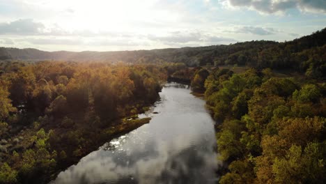 Aerial-shot-over-river-at-sunset-during-the-summer