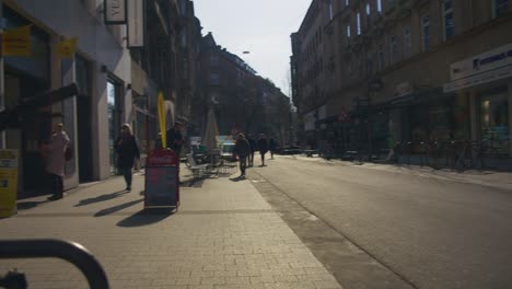 Mann-Fährt-Auf-Dem-Fahrrad-Vorbei,-Während-Menschen-Gehen---Schlossplatz-In-Der-Innenstadt-Von-Stuttgart-In-4K,-Klassische-Deutsche-Architektur,-Berühmt,-Rotes-Komodo-Cooke-Mini-S4i-Objektiv-In-Premiumqualität-|-Nachricht