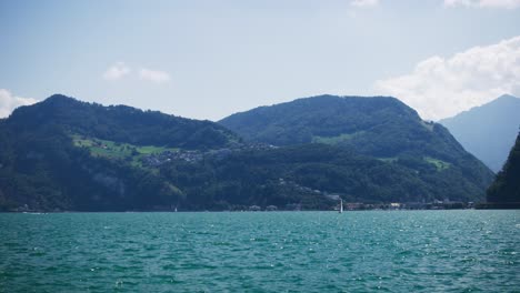 Friedlicher-Blick-Auf-Ein-Einzelnes-Segelboot-In-Der-Ferne-Auf-Dem-Bergsee---Hergiswil-Schweiz-Berge-In-4k