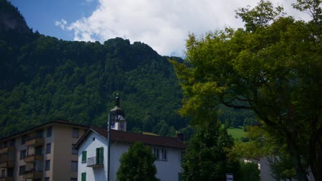 Baum-In-Der-Nähe-Der-Kirche-Im-Dorf---Hergiswil,-Schweiz,-Berge-In-4k