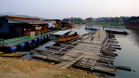 Schwimmende-Häuser-Und-Bambuswege,-Thailändische-Boote-Und-Menschen